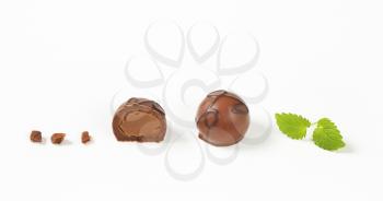 one and half belgian chocolate pralines on white background