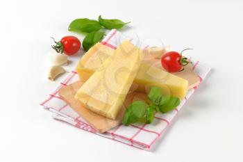 wedges of fresh parmesan cheese on wooden cutting board