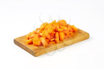heap of chopped carrots on wooden cutting board