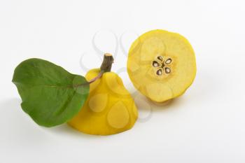 close up of halved yellow pear on white background