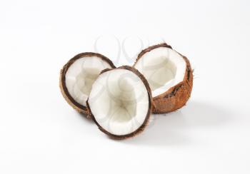 three fresh coconut halves on white background