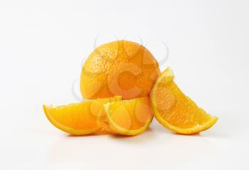 Whole orange and three slices on white background