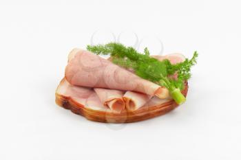 stack of ham slices and dill on white background