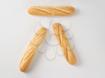 three small french baguettes on white background