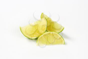 three slices of fresh lime on white background