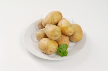 raw unpeeled potatoes on plate