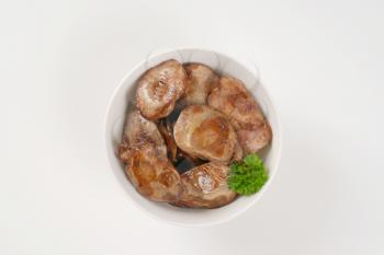 bowl of pan fried chicken liver on white background