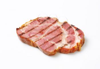 Grilled slice of smoked pork neck on white background