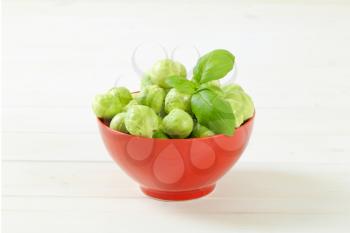 bowl of raw Brussels sprouts on white background
