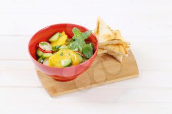 radish and cucumber salad with orange and toasted bread