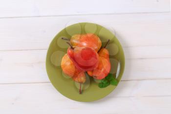 plate of ripe red pears on white background