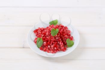 plate of pomegranate seeds on white background