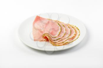 slices of asparagus coated ham on white plate