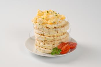 slices of puffed rice bread with scrambled eggs on white plate