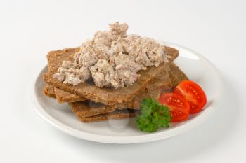 slices of fitness bread with fish spread on white plate