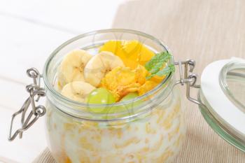 jar of corn flakes with milk and fresh fruit - close up