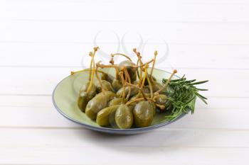 plate of pickled caper berries with stems on