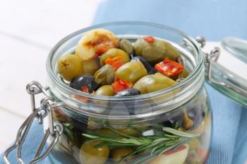 jar of pickled olives, capers, caper berries and garlic