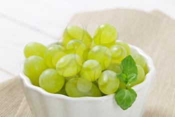 bowl of white grapes on beige place mat - close up