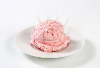 single scoop of strawberry ice cream on white plate