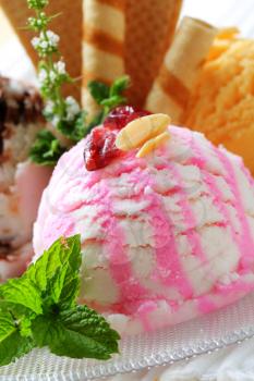 Scoops of ice cream garnished with wafers and herbs