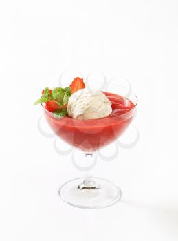 Scoop of vanilla ice cream with strawberry puree in coupe glass