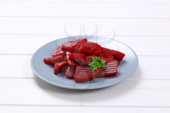 plate of sliced and pickled beetroot on white wooden background