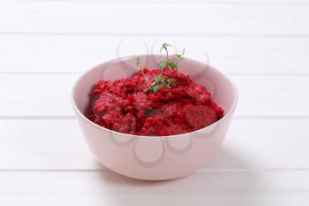 bowl of fresh beetroot puree on white wooden background