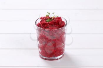 glass of fresh beetroot puree on white wooden background