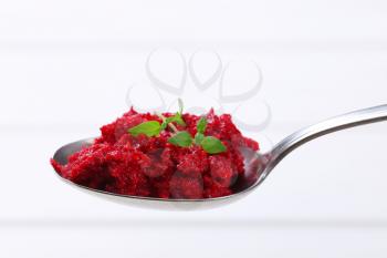 spoon of fresh beetroot puree on white background