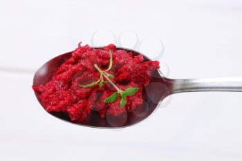 spoon of fresh beetroot puree on white background