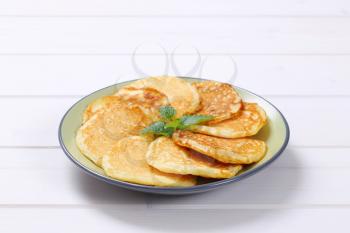 plate of fresh american pancakes on white wooden background