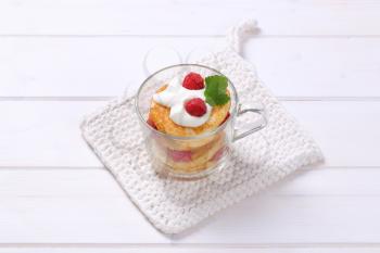 cup of american pancakes with white yogurt and fresh raspberries on white table mat