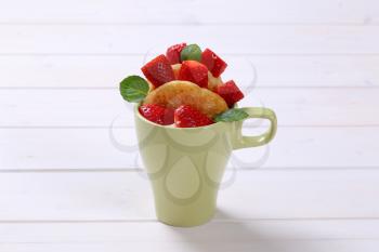 cup of american pancakes with white yogurt and fresh strawberries on white wooden background