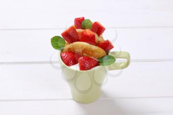 cup of american pancakes with white yogurt and fresh strawberries on white wooden background