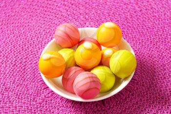 White chocolate pralines with fruit ganache filling in a bowl