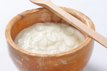 bowl of semolina pudding and wooden spoon - detail