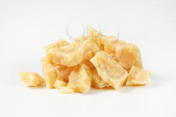 Pieces of Parmesan cheese on white background