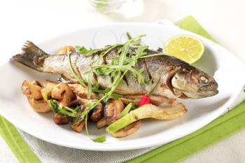 Grilled trout served with button mushrooms