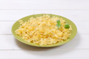 plate of quadretti - square shaped pasta on white wooden background