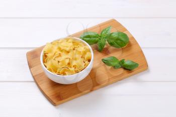 bowl of quadretti - square shaped pasta on wooden cutting board