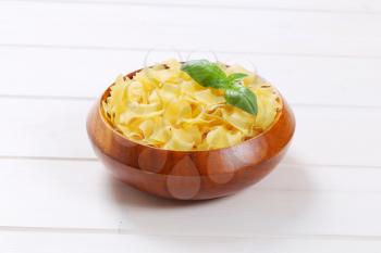 bowl of quadretti - square shaped pasta on white wooden background