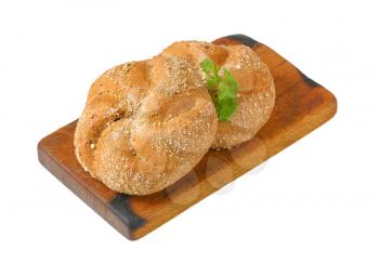 two whole wheat buns on wooden cutting board