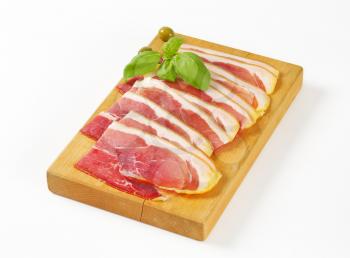 Sliced prosciutto crudo on cutting board