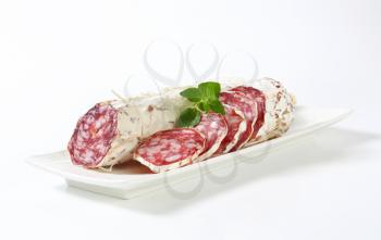 Sliced French Saucisson Sec on long white plate