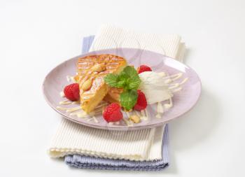 Slice of almond cake with ice cream and fresh raspberries