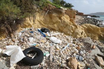 Litter and discarded old tires on the sea shore in Malta