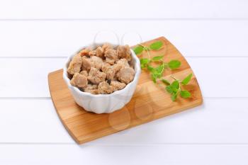 bowl of soy meat cubes on wooden cutting board