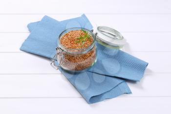 jar of raw buckwheat on blue place mat