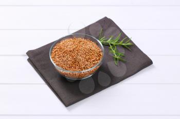 bowl of raw buckwheat on grey place mat